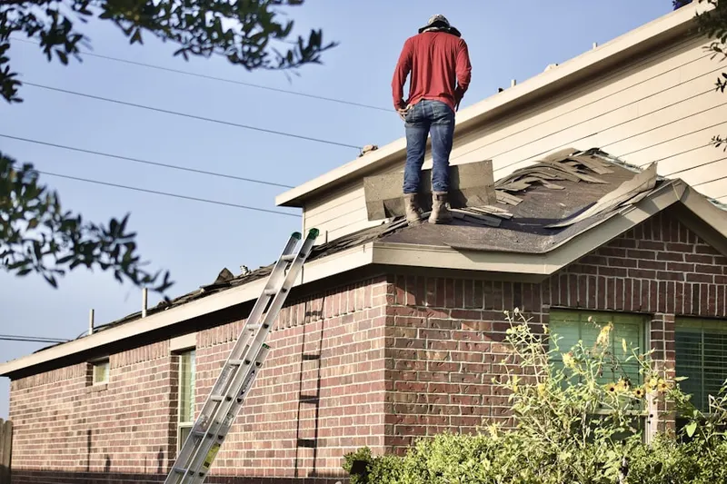 Professional roofer working on a residential roof in Clayton Manor